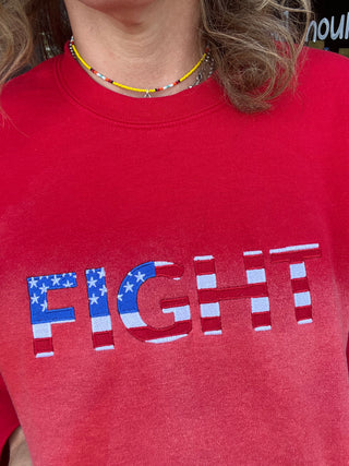 closeup of red hand bleached sweatshirt on girl with embroidered FIGHT on front